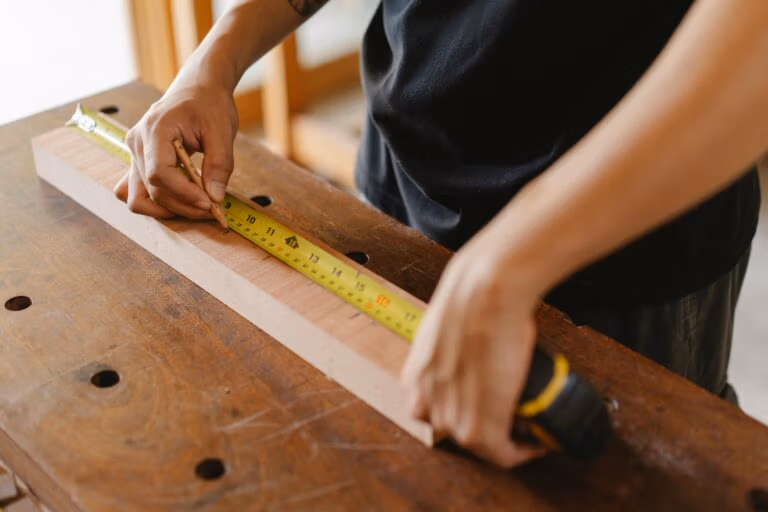 worker measuring a piece of wood